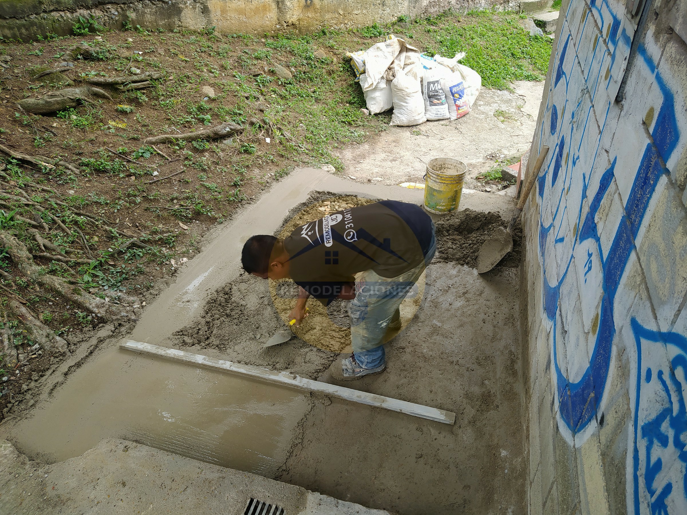 oficial de construcción vaciando acera de casa