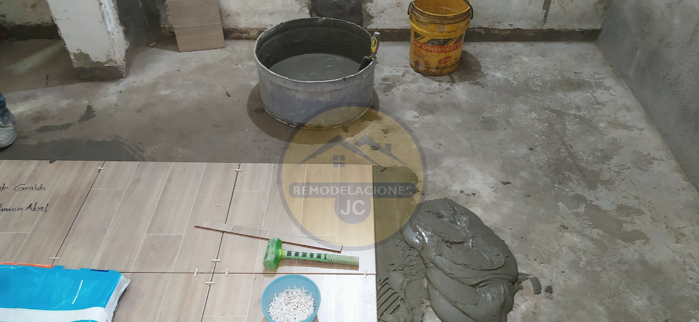 regando mega pega de corona para instalar cerámica en piso de casa en Medellín belén