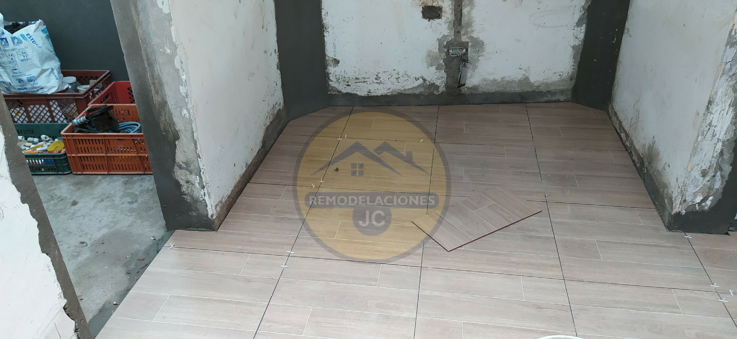 proceso de instalación de cerámica en piso de casa antigua que esta siendo remodelada