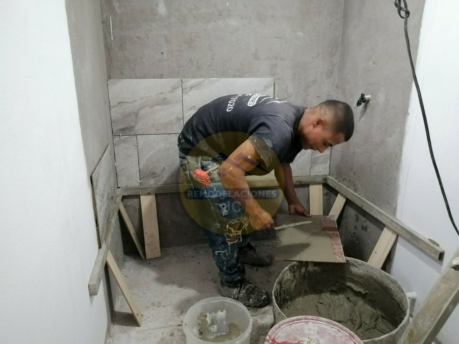 enchapador preparando baldosa y pegacor para instalación en paredes