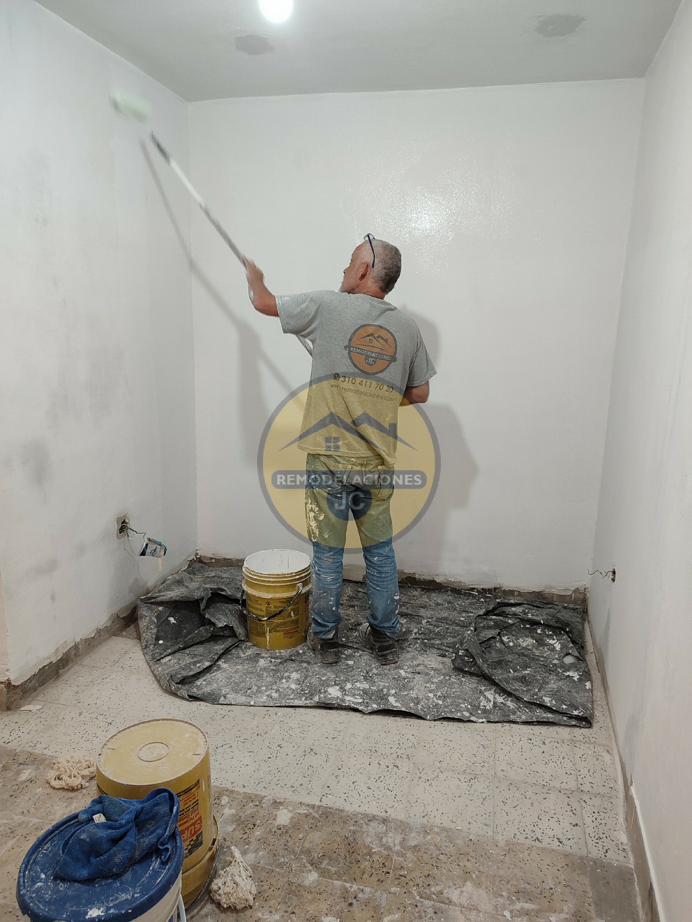 trabajador de pintura y estuco pintando pared de casa en Medellín y sus alrededores