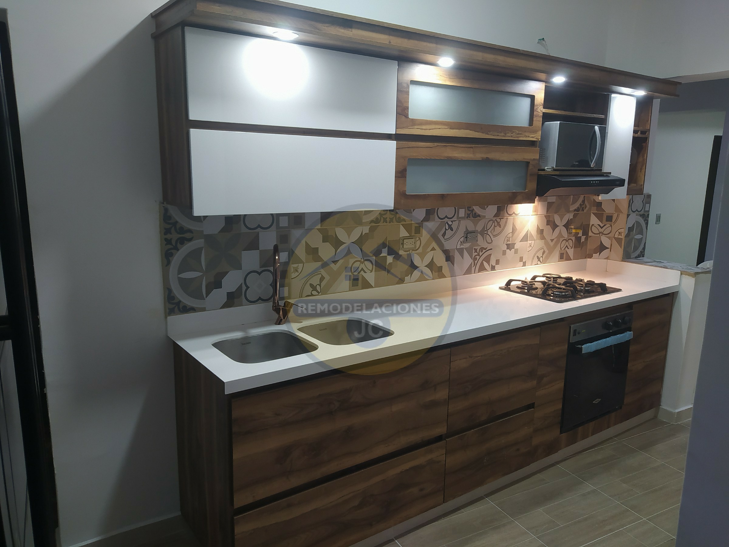 cocina en madecor con mesón blanco, doble pozuelo lavaplatos, grifería, sifón flexible y electrodomésticos en casa